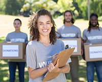 This image of a group of smiling volunteers represents the value of successful volunteer recruitment strategies.