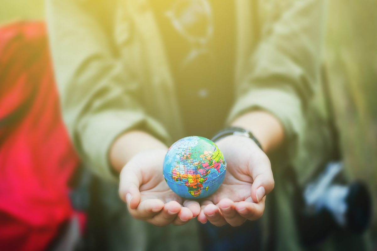 This is an image of someone holding a globe in their hands, representing the idea of attracting donors during their nonprofit search.