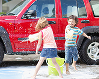 Washing cars at a sunny outdoor fundraiser, helping families raise adoption funds through community service.