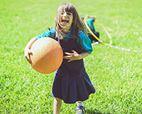 Children playing kickball at a community adoption fundraiser, combining fun and fitness for adoption costs.