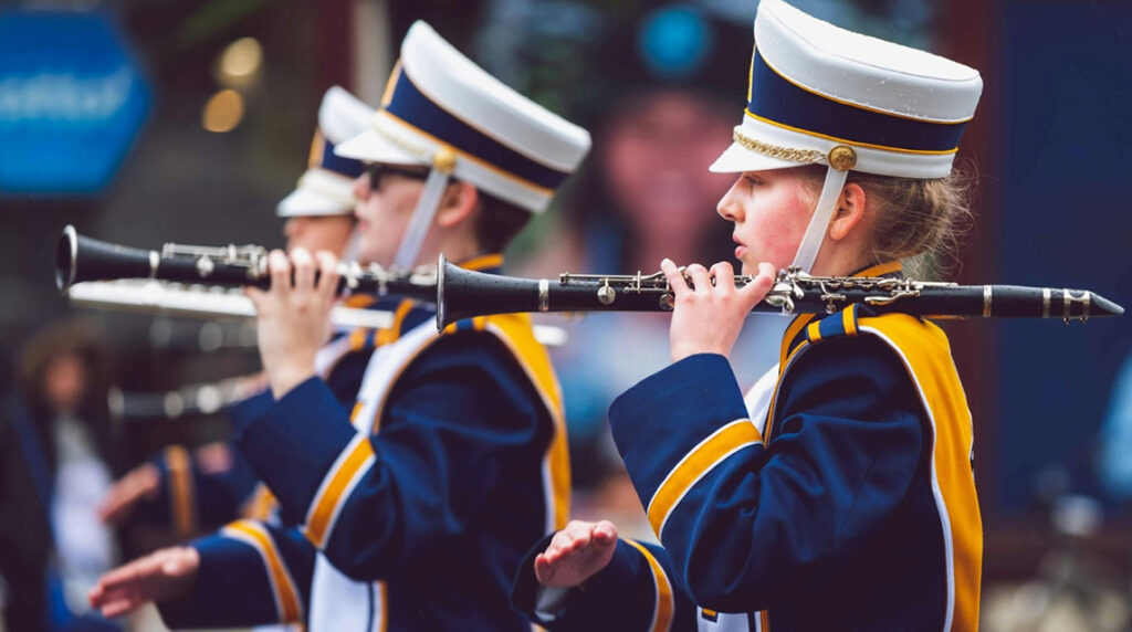 Three clarinet players march as part of their band’s halftime show.