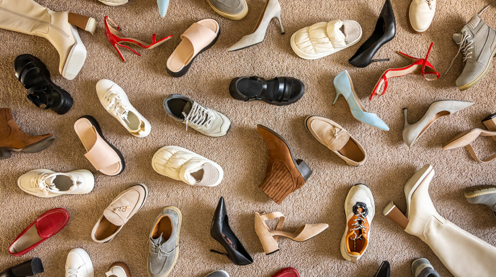 Different shoes arranged in an abstract pattern on a beige carpet floor that illustrates holiday fundraiser ideas for a shoe drive fundraising campaign.