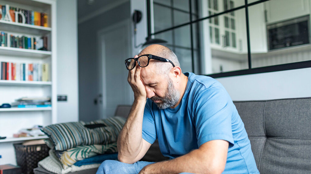 Man with his head in his hand out of frustration for donor fatigue.