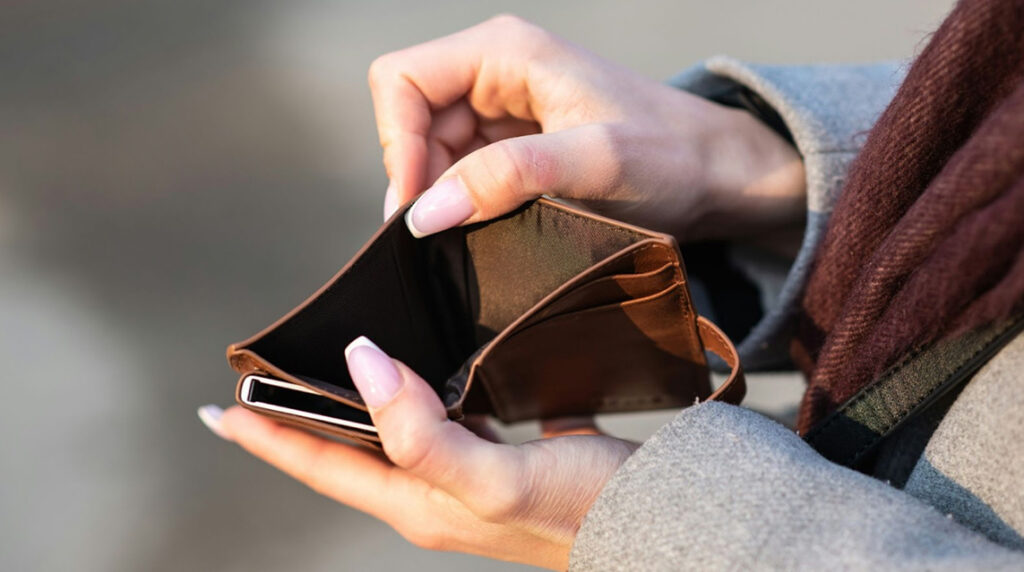 A close-up of a person’s hands holding an empty wallet open.