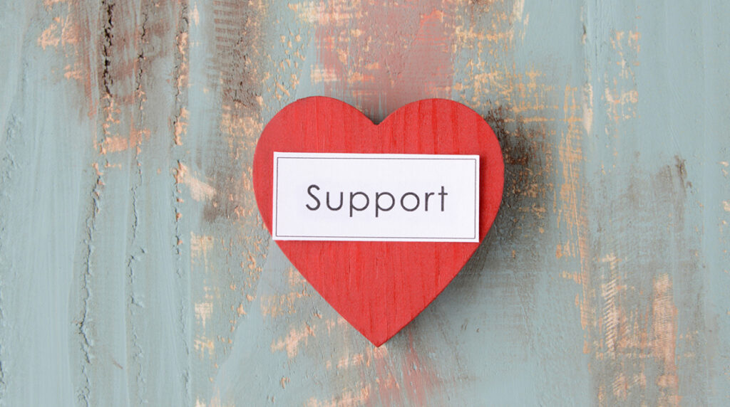 Red wooden heart with "support" text representing nonprofit donation requests