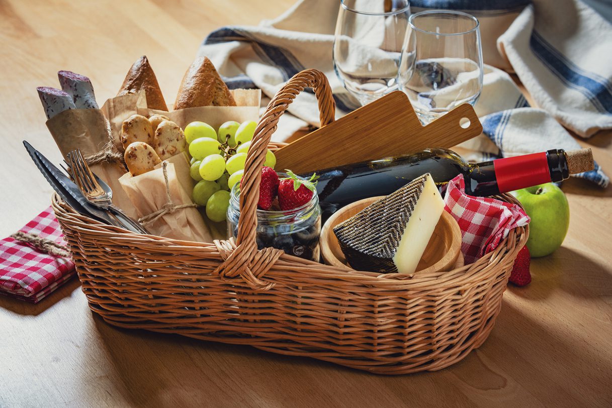 Basket filled with food and drinks on a table being prepared for a silent auction.